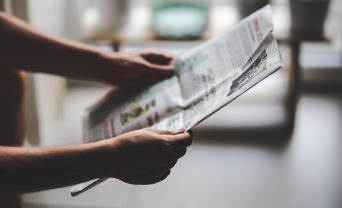 Woman's hands holding newspaper