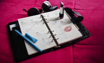 Woman's calendar lay out on a pink bedspread