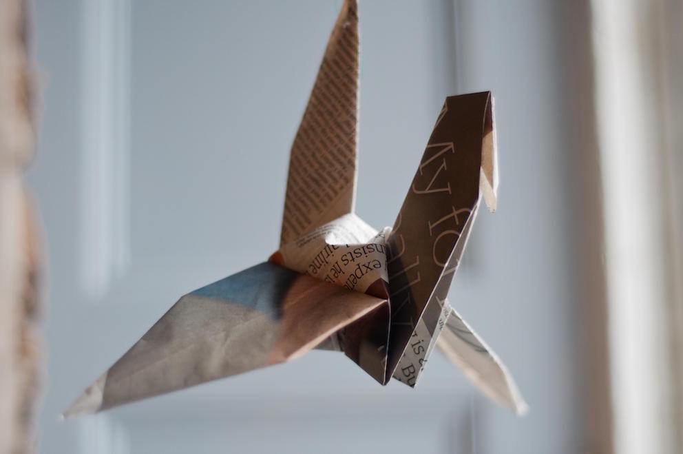 Newspaper article folded into a paper crane
