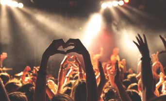 Audience member makes a heart shape with her hands