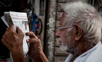 Elderly man reads a newsletter